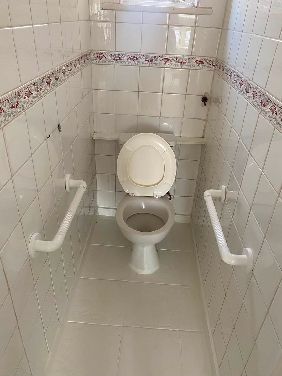 Tiled cloakroom with WC and grab rails, cleaned
